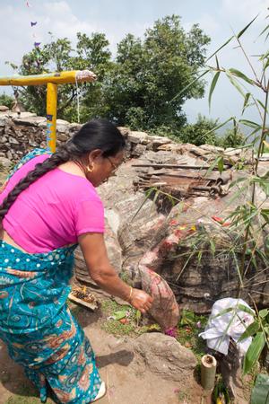 Rai woman placing offerings in front of the weaving stone of Toma during the Tuwachung-Jayajum festival