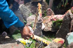 A person lighting incense as offering at the place of worship for Khema at Tuwachung-Jayajum festival