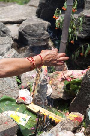 A woman lighting incense as offering at the place of worship for Khema at Tuwachung-Jayajum festival