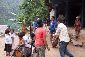 Boy beats the drum while villagers are dancing sakela in the courtyard
