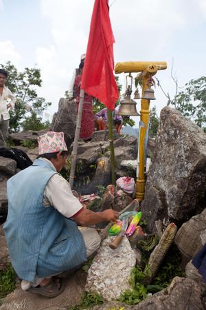 Participants of Tuwachung-Jayajum festival winding white cotton thread around the stones of the place of worship for Khema