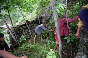 Villagers are cleaning the bhume than (sakela than) from overgrowth