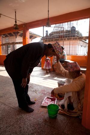 Chatur Bhakta Rai receiving a tikka (blessing) from a priest in Pindeshwor temple
