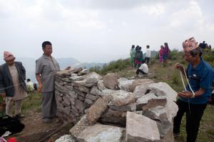 Participants of Tuwachung-Jayajum festival winding white cotton thread around the stones of Khema weaving stones