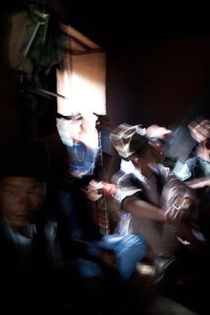 The ritual specialist, Prem Bahadur Rai (Salghare), and his crew are discussing while resting inside a house after the rituals are finished