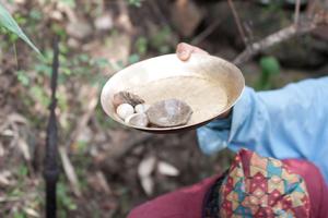 A ritual assistant presents the sakela stones